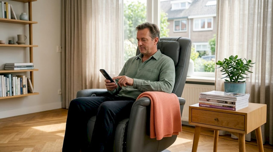 Een man zit thuis ontspannen in zijn massage stoel en kiest via het bedieningspaneel het gewenste programma.